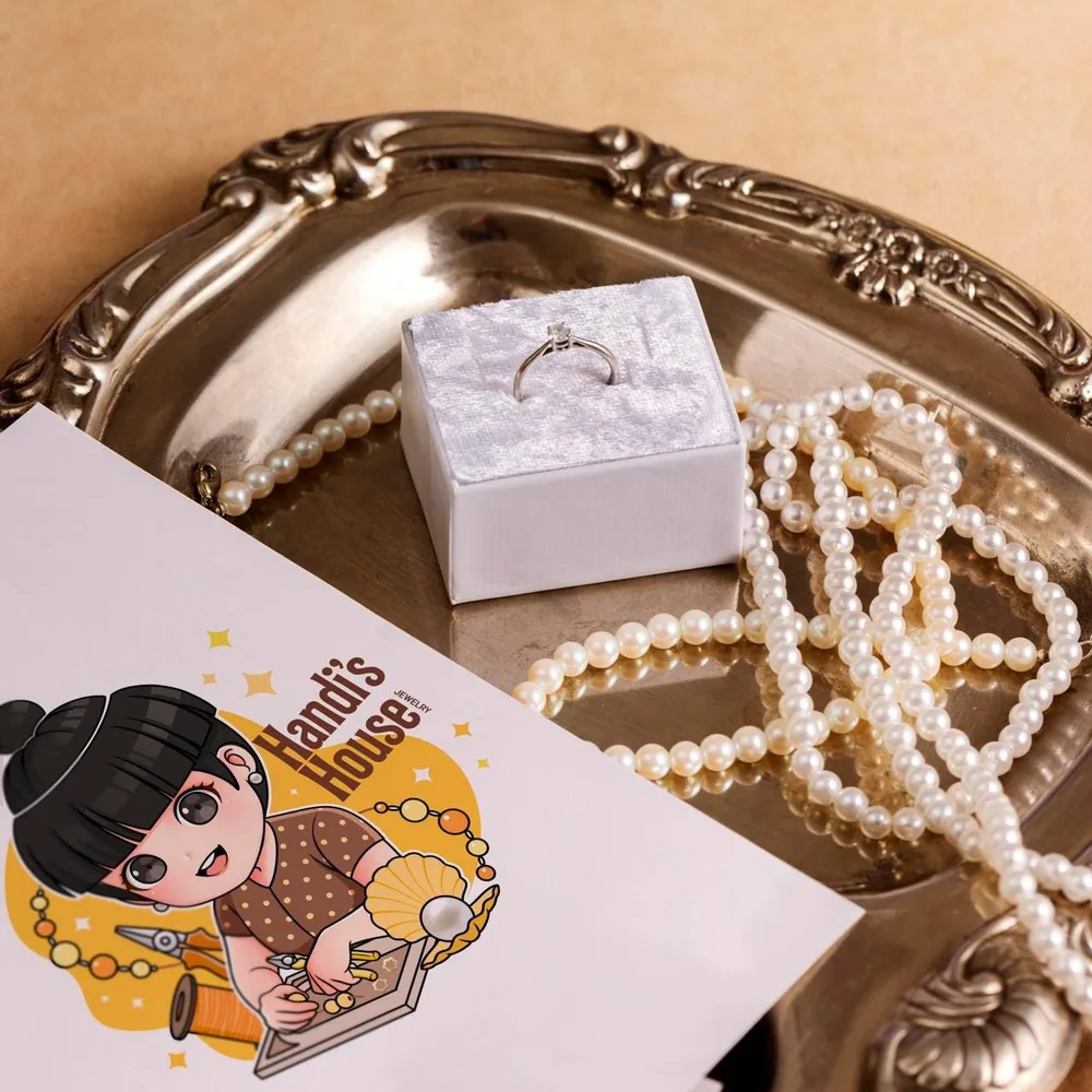 Pearls and a ring arranged on a vintage silver tray